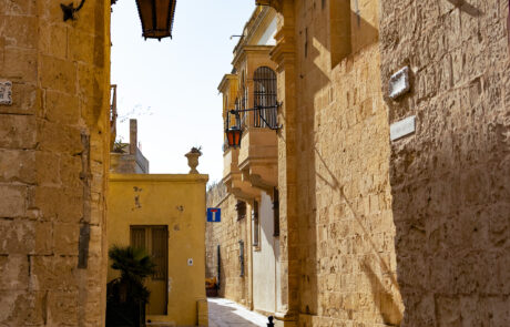 Quiet limestone alley with a hanging lantern in Mdina, Malta