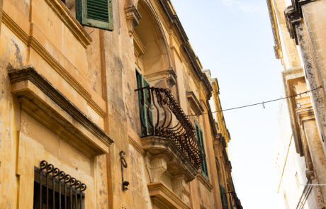 Limestone building facades with iron balconies in Mdina, Malta