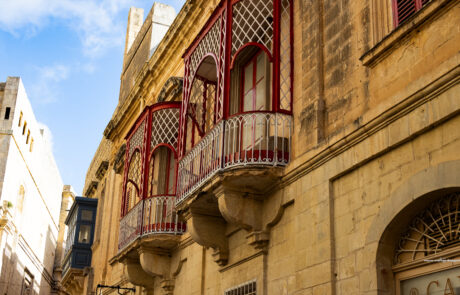 Traditional Maltese balconies on golden limestone buildings in Mdina