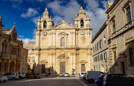 Cathedral facade with parked cars on a Mdina street, Malta