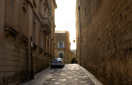 Narrow stone alley between tall buildings in Mdina, Malta