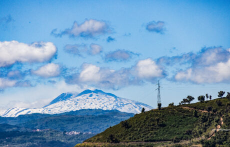 Snow-capped Mount Etna seen from a hillside road