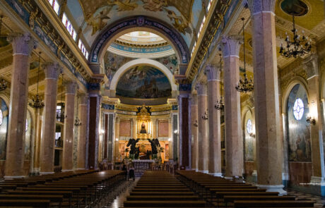 Basilica nave interior with rows of pews and a frescoed ceiling at Tindari