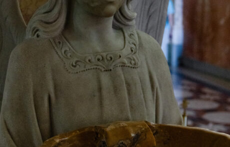 Statue of an angel holding a holy water font inside the Tindari basilica