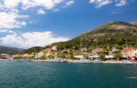 Coastal harbor town with boats and hillside houses at Kefalonia