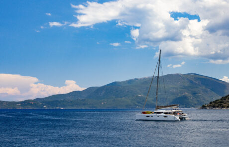 Sailboat anchored in a calm bay with green hills at Kefalonia