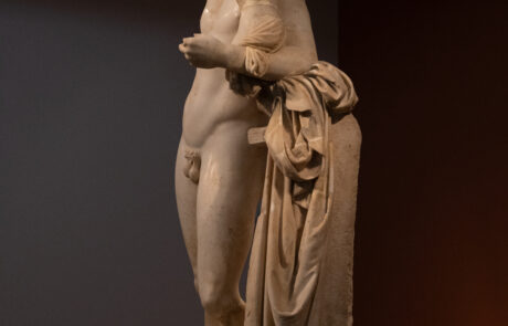 Marble statue of a man holding an infant at the Olympia Archaeological Museum