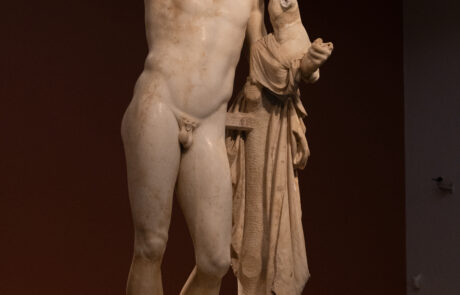 Marble statue of a man holding an infant at the Olympia Archaeological Museum