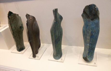 Row of ancient bronze figurine fragments at the Olympia Archaeological Museum
