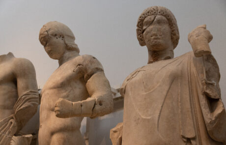 Group of ancient marble statues of robed figures at the Olympia Archaeological Museum