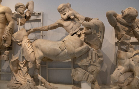 Ancient marble relief sculpture depicting a mythological battle scene at Olympia museum