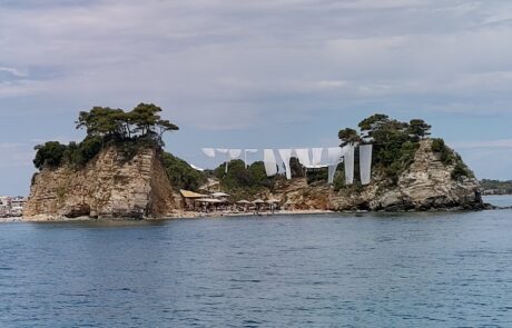 Small islet with white buildings connected to the shore, Zakynthos coast