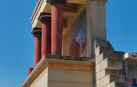 Reconstructed red columns and ancient stone facade at the Palace of Knossos