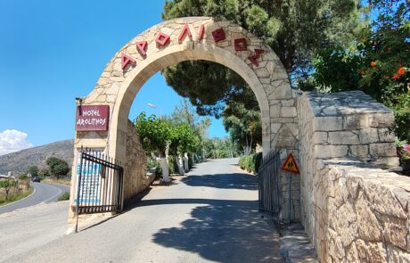 Village entrance archway with signage over the road at Arolithos
