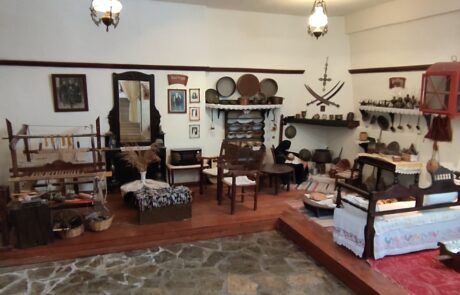 Traditional furnished museum room with folk artifacts on the walls at Arolithos village
