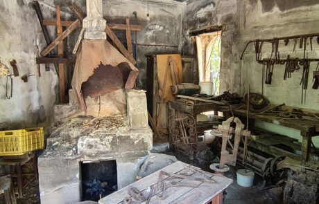 Rustic traditional workshop interior with hanging tools at Arolithos village