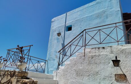 Light-blue traditional house with white outdoor staircase at Arolithos village