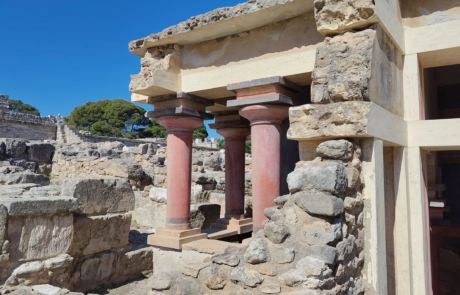 Reconstructed red columns among ancient ruins at the Palace of Knossos