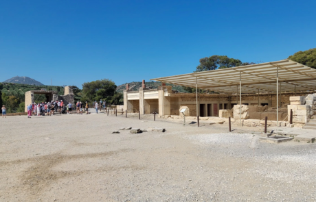 Wide view of the Knossos archaeological site with visitors and a shaded pavilion