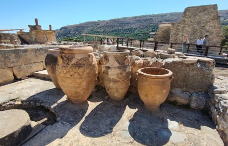 Large ancient storage jars (pithoi) among ruins at the Palace of Knossos