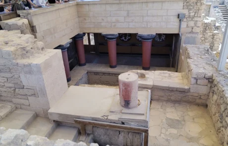Ancient stone chamber ruins with red-topped walls at the Knossos archaeological site