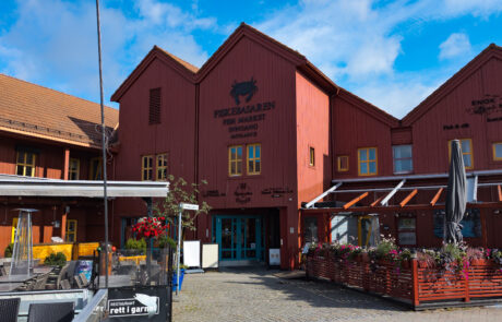 Red market building with outdoor cafe seating, Kristiansand, Norway