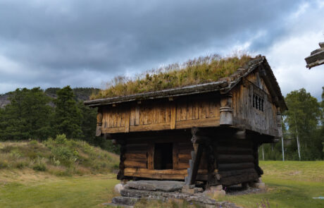 Old wooden log building with a grass roof at an open-air museum