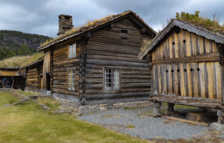 Old wooden log cabins with grass roofs at an open-air museum