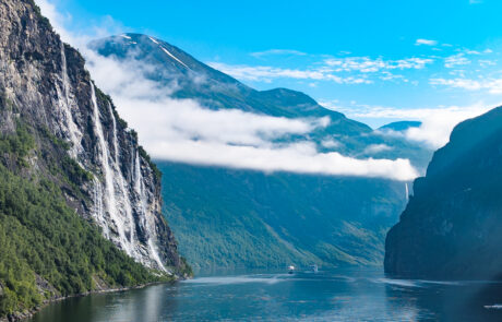 Geirangerfjord with Seven Sisters waterfalls cascading down a cliff beneath clouds