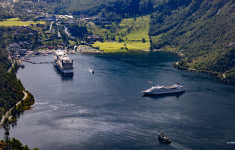 Aerial view of Geiranger village and harbor with ships surrounded by green hills