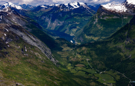 Aerial view of a winding mountain road descending toward the Geirangerfjord, Norway