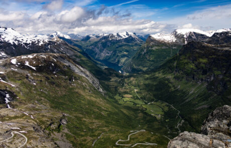 Aerial view of a winding mountain road descending toward the Geirangerfjord, Norway