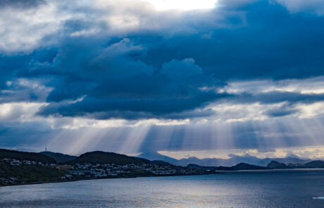 Coastal town view across the bay under a blue sky with scattered clouds