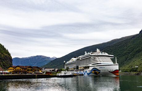 Fjord village with a cruise ship docked among the mountains, Flam, Norway