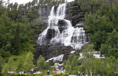 Waterfall cascading down a rocky cliff surrounded by forest
