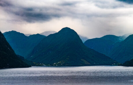 Layered mountain silhouettes over a fjord at dusk, Flam, Norway