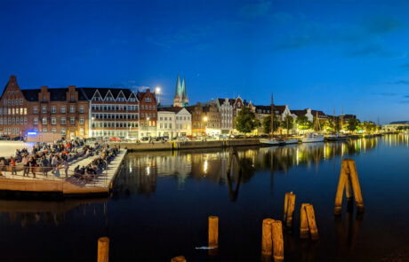 Night panorama of Drehbrueckenplatz with illuminated restaurant boats reflected in the water