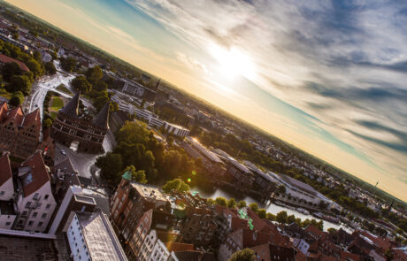 Aerial view of Luebecks Holstentor gate and old town at sunset with sun flare