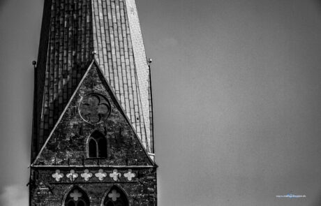 Black-and-white photo of St. Marien church tower against the sky in Luebeck