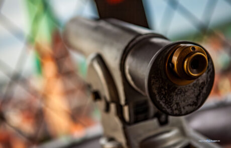 Close-up of an old brass telescope with St. Petri church tower blurred in the background, Luebeck