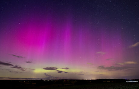Pink and green aurora borealis over the night sky at Pariner Berg