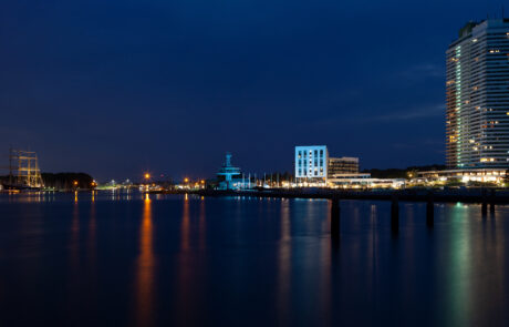 Night panorama of the Trave river in Travemuende with illuminated buildings
