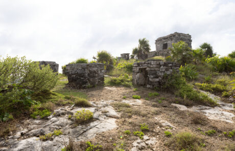 Distant view of stone ruins on a coastal bluff above the sea, Tulum