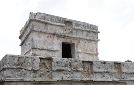 Mayan pyramid-style stone temple ruins against a cloudy sky, Tulum