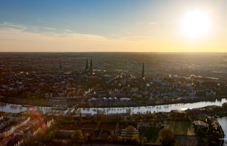 Aerial view from a hot air balloon over Luebeck at sunset with the river winding through the city