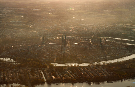 Aerial view from a hot air balloon over Luebecks winding river in hazy golden light