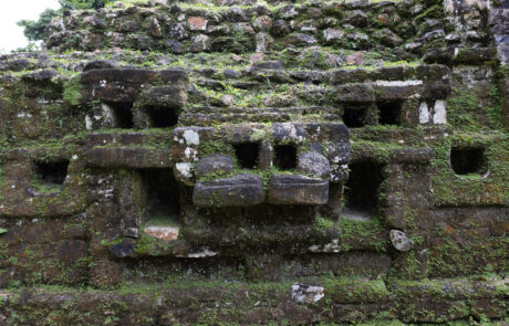 Close-up of a moss-covered carved stone temple facade, Lamanai