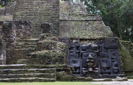 Close-up of a Mayan stone pyramid with a carved mask, Lamanai