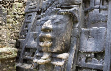 Close-up of a carved stone Mayan mask sculpture at Lamanai